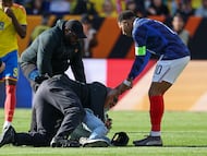 France's forward #10 Kylian Mbappe assists a fan who jumped onto the field to greet him as he's restrained by security at the end of a friendly football match between Colombia and France at Northwest Stadium in Landover, Maryland, on March 29, 2026. (Photo by FRANCK FIFE / AFP)