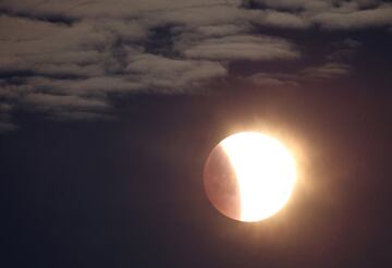 La luna se ve mientras una secci¨®n se mueve hacia la sombra durante un eclipse lunar, fotografiado cerca del c¨ªrculo de piedras de Stonehenge, Amesbury, sur de Gran Breta?a.
