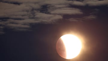 The moon is seen as a section moves into shadow during a lunar eclipse, photographed near Stonehenge stone circle, Amesbury, southern Britain, March 14, 2025. REUTERS/Toby Melville TPX IMAGES OF THE DAY