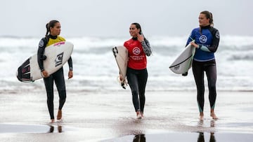 Tres surfistas salen del agua con sus licras de colores tras participar en una manga de la SuperLiga Siroko 2019, el circuito nacional de surf que visita Cantabria, Asturias, el País Vasco y Galicia.