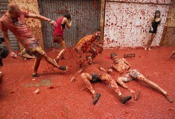 Revellers covered in tomato pulp take part in the annual "Tomatina" festival in the eastern town of Bunol, on August 30, 2017.
The iconic fiesta -- which celebrates its 72nd anniversary and is billed at "the world's biggest food fight" -- has become a major draw for foreigners, in particular from Britain, Japan and the United States. / AFP PHOTO / JAIME REINA