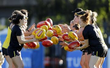 Las jugadoras del equipo femenino de Richmond realizan un ejercicio de destreza con varios balones de rugby, como si de un juego de malabarismo se tratase. La imagen fue tomada durante el entrenamiento del equipo inglés en el Punt Road Oval de Melbourne, un antiguo óvalo de críquet reconvertido en campo de fútbol australiano.