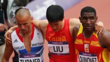 Jackson Quiñónez, a la derecha, ayuda a salir de la pista a Liu Xiang, lesionado.
