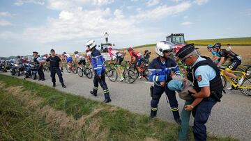 Cycling - Tour de France - The 218-km Stage 16 from Carcassonne to Bagneres-de-Luchon - July 24, 2018 - Police officers carry a protester off the road as the peloton passes. REUTERS/Stephane Mahe