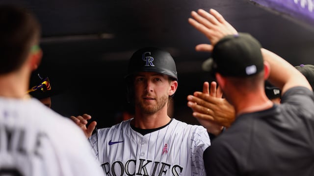 DENVER, CO - MAY 11: Ryan McMahon #24 of the Colorado Rockies is congratulated in the dugout after scoring in the seventh inning against the San Diego Padres at Coors Field on May 11, 2025 in Denver, Colorado. Justin Edmonds/Getty Images/AFP (Photo by Justin Edmonds / GETTY IMAGES NORTH AMERICA / Getty Images via AFP)