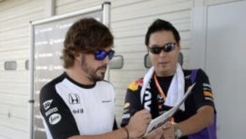 Fernando Alonso firmando un aut&oacute;grafo a un aficionado.