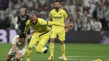 Real Madrid's Spanish forward #21 Brahim Diaz (L) falls down on the pitch as he fights for the ball with Villarreal's French midfielder #06 Etienne Capoue during the Spanish league football match between Real Madrid CF and Villarreal CF at the Santiago Bernabeu stadium in Madrid on December 17, 2023. (Photo by Thomas COEX / AFP)