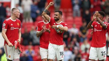 Manchester United&#039;s Portuguese midfielder Bruno Fernandes (C) holds the match ball as he reacts with teammates at the final whistle during the English Premier League football match between Manchester United and Leeds United at Old Trafford in Manches