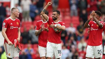 Manchester United's Portuguese midfielder Bruno Fernandes (C) holds the match ball as he reacts with teammates at the final whistle during the English Premier League football match between Manchester United and Leeds United at Old Trafford in Manches