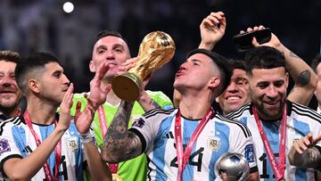 Argentina's midfielder #24 Enzo Fernandez lift the FIFA World Cup Trophy and holds holds the Young Player award during the Trophy ceremony as he celebrates with teammates winning the Qatar 2022 World Cup final football match between Argentina and France at Lusail Stadium in Lusail, north of Doha on December 18, 2022. (Photo by Kirill KUDRYAVTSEV / AFP)