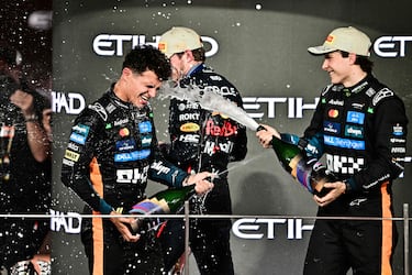 Lando Norris celebra en el podio lanzándose chámpan junto a su compañero de McLaren Oscar Piastri y el tetracampeón del mundo, Max Verstappen.