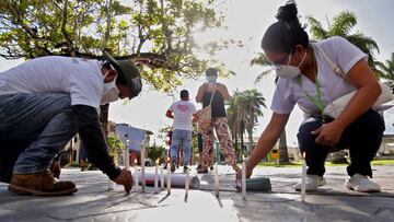 Relatives and friends of medical staff who died from the new coronavirus contracted because of working on the front line, take part in a vigil outside the regional government building in the Amazon city of Iquitos, Peru, on June 5, 2020, to protest against the insensitivity of mass burials and in demand of the exhumation of bodies for DNA identification. - According to Peruvian authorities, 146 police officers, 61 medical doctors and paramedics, 20 journalists and eight firefighters are among the 5,162 victims from the 187,400 reported infected with COVID-19 nationwide. Peru is the second Latin American country with most cases of infected population after Brazil. (Photo by Cesar Von BANCELS / AFP)