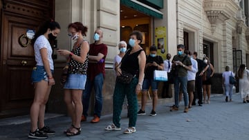 23/07/2020 Decenas de personas protegidas con mascarilla hacen cola para entrar en una biblioteca, en Barcelona, Catalunya (Espa&ntilde;a), a 23 de julio de 2020. Catalu&ntilde;a celebra este jueves un D&iacute;a del Libro y de la Rosa aplazado tras no po