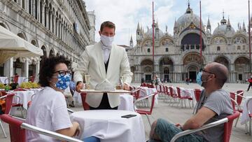 Dos turistas son atendidos en el 'Caffe Quadri' de la plaza de San Marco.