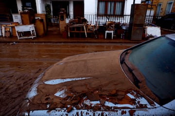 El barro cubre un coche y las pertenencias de varias personas tras las inundaciones en Utiel, España.