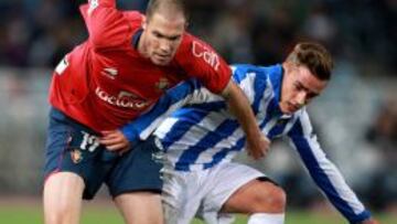 El centrocampista francés de la Real Sociedad, Antoine Griezmann, lucha el balón con Fernando Macedo "Nano", de Osasuna, durante un partido.