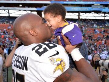 Adrian Peterson de los Minnesota Vikings besa a su hijo.