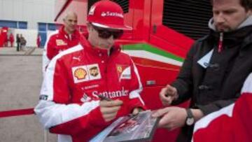 Kimi Raikkonen firmando aut&oacute;grafos durante la tercera jornada de los entrenamientos.