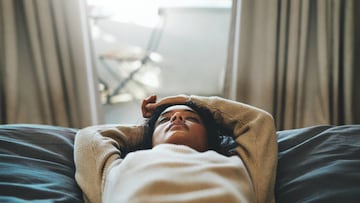 Cropped shot of a young woman lying on her bed with her eyes closed