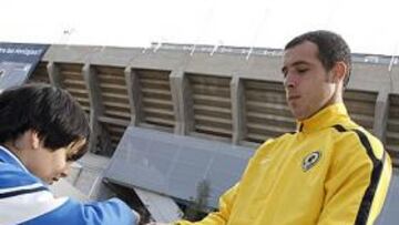 <b>MOTIVADOS. </b>El jugador del Hércules Urko Vera firma un autógrafo ayer antes de viajar a Huelva.