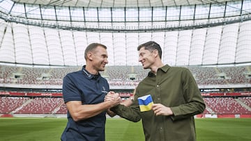 El exfutbolista ucraniano Andriy Shevchenko hace entrega a Robert Lewandowski, capitán de Polonia, de un brazalete con los colores de la bandera de Ucrania en el Estadio PGE Narodowy, en Varsovia. El delantero del Barça se ha comprometido a llevarlo durante los partidos de su selección en la próxima Copa del Mundo de Qatar.