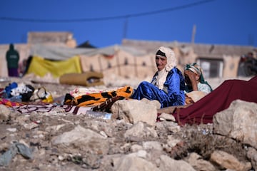 Una mujer llora sentada entre los escombros provocados por el terremoto.