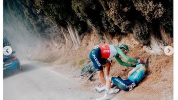 El ciclista italiano Alberto Bettiol asiste a su compañero Cristian Scaroni tras su caída en la Strade Bianche.