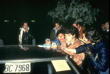 Diego Maradona firmando autógrafos a seguidores por las calles de Buenos Aires.