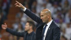 Zinedine Zidane, entrenador del Real Madrid, da instrucciones a sus jugadores en un partido contra el Atl&eacute;tico, con Simeone al fondo.