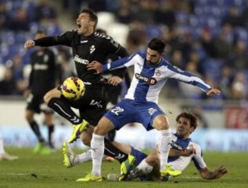 El delantero mexicano del Eibar Federico Piovaccari (i) cae ante Álvaro y Vìctor Gracía (d), del RCD Espanyol, durante el partido de la decimo séptima jornada de Liga de Primera División