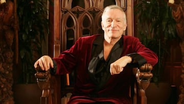 Hugh Hefner, el fundador del Imperio Playboy, sentado en una silla tallada de madera