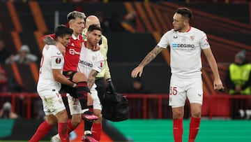 MANCHESTER, ENGLAND - APRIL 13: Argentina internationals, Marcos Acuna of Sevilla and Gonzalo Montiel of Sevilla carry off Lisandro Martinez of Manchester United after an injury during the UEFA Europa League quarterfinal first leg match between Manchester United and Sevilla FC at Old Trafford on April 13, 2023 in Manchester, United Kingdom. (Photo by Matthew Ashton - AMA/Getty Images)