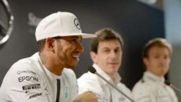 Lewis Hamilton habla bajo la atenta mirada de Toto Wolff y Nico Rosberg.