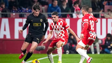 Girona, 15/03/2025. El centrocampista del Valencia, Javi Guerra (i), con el balón ante el defensa del Girona, Miguel Gutiérrez, durante el encuentro correspondiente a la jornada 28 de Laliga EA Sports que disputan hoy sábado Girona y Valencia en el estadio Montilivi de la capital gerundense. EFE/David Borrat.