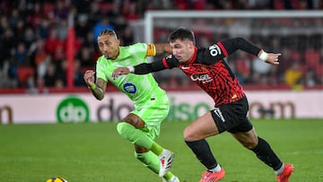 PALMA, 03/12/2024.- El centrocampista del Mallorca Valery Fernández (d) disputa un balón ante el delantero brasileño del Barcelona Raphinha, durante el partido de LaLiga de la jornada 19 entre el Real Mallorca y el Barcelona, que se disputa este martes en el estadio de Son Moix.- EFE/ Miquel A. Borràs