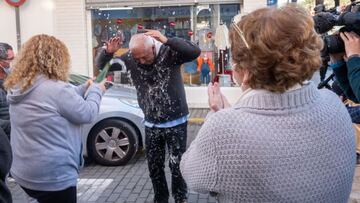 GRAFAND5029. PUNTA UMBRÍA (HUELVA), 22/12/2020.- Varias personas celebran que les ha tocado el Gordo de la Lotería de Navidad en la localidad onubense de Punta Umbría, cuya administración se ha estrenado hoy, después de 50 años de actividad, con la venta íntegra de los 600 décimos del número 72897 que han dejado en el pueblo 240 millones de euros. EFE/Julián Pérez