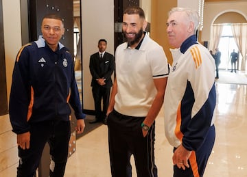 Karim Benzema charla con Kylian Mbapp y Carlo Ancelotti durante su visita al equipo. 