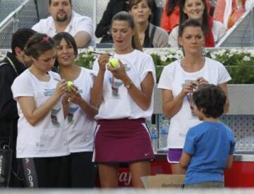  Las modelos Laura Sánchez (2d) y Cristina Pedroche (2i), junto a la tenista polaca Agnieszka Radwanska (d), firman pelotas durante los partidos benéficos del 'Charity Day' previo al Mutua Madrid Open de Tenis 2014.