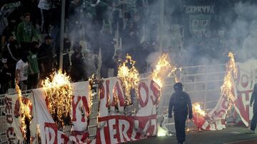 Fans burn a banner in front of stands during a Greek Super League soccer match inside the Athens' Olympic stadium, in Athens, Sunday, March 17, 2019. The derby between Greek league archrivals Panathinaikos and Olympiakos has been abandoned after a sm