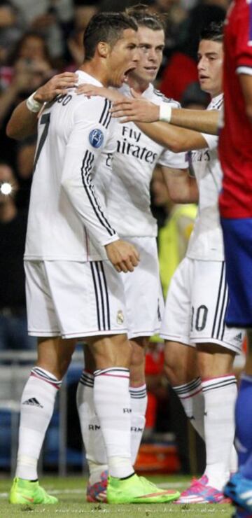 El delantero portugués del Real Madrid Cristiano Ronaldo (i) celebra su gol, tercero del equipo, con el galés Gareth Bale (c) y el colombiano James Rodríguez, durante el partido de la primera jornada de la fase de grupos de la Liga de Campeones que Real Madrid y FC Basilea disputan esta noche en el estadio Santiago Bernabéu, en Madrid. 