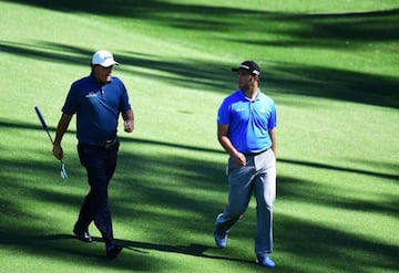 Phil Mickelson of the United States and Jon Rahm of Spain walk the tenth hole during a practice round.