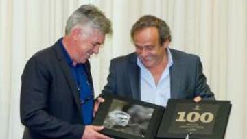 Ancelotti recibe la placa de manos de Platini.