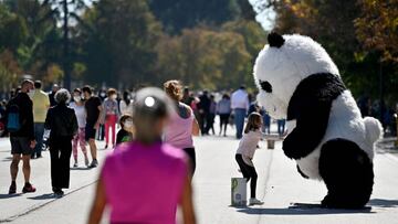A girl plays with a street performer dressed as a panda as people wearing face masks to prevent the spread of the coronavirus take a stroll at the Retiro Park in Madrid on October 10, 2020. - Spain&#039;s government declared a state of emergency and new p