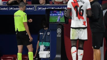 Spanish referee Javier Iglesias Villanueva (L) checks the Video Assistant Referee (VAR) monitor during the Spanish league football match between Club Atletico de Madrid and Rayo Vallecano de Madrid at the Wanda Metropolitano stadium in Madrid on October 18, 2022. (Photo by OSCAR DEL POZO CANAS / AFP)