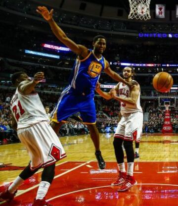 Jimmy Butler y Joakim Noah luchan por el balón con Hilton Armstrong.