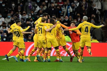 Barcelona's players celebrate after scoring a goal during the Spanish League football match between Real Madrid CF and FC Barcelona at the Santiago Bernabeu stadium in Madrid on March 20, 2022.