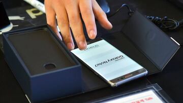 A South Korean employee provides a replacement Samsung Galaxy Note7 smartphone at a telecommunications shop in Seoul on September 19, 2016.
 Samsung started on September 19 to provide users of its Galaxy Note 7 smartphone the first batch of replacements with new batteries, after a series of battery explosions prompted a major recall worldwide. / AFP PHOTO / JUNG YEON-JE