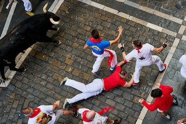 Participantes corren delante de los toros durante el primer encierro de los Sanfermines en Pamplona.