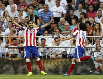 El centrocampista del Atlético de Madrid Raúl García (i) celebra con su compañero, el portugués Tiago Mendes (d), el gol marcado al Real Madrid, durante el partido de la tercera jornada de Liga de Primera División, disputado esta tarde en el estadio Santiago Bernabéu. 