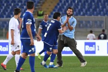 ROM01. ROMA (ITALIA), 12/10/2016.- Un hombre entra al campo de juego (d) y saluda a la leyenda del fútbol argentino Diego Armando Maradona (c) durante un partido de beneficencia 'Partido de la Paz- Unidos por la Paz' hoy, miércoles 12 de octubre de 2016, que es promovido por la fundación Escuelas del Encuentro, una organización impulsada por el papa Francisco, en el estadio Olímpico en Roma (Italia).